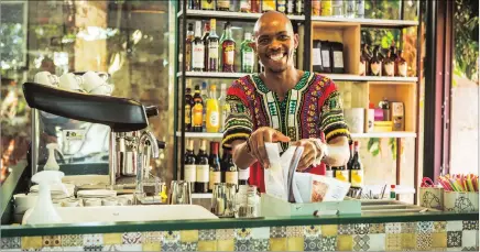  ??  ?? OUTSIDE OF THE BOX: Vibrant Freedom Cafe team member Xolani Gumede grins from behind the bar.