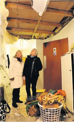  ??  ?? Roof justice Co-founders and sisters Roslyn McGilvray (left) and Anne Marie Cocozza inspect the damage in the hallway