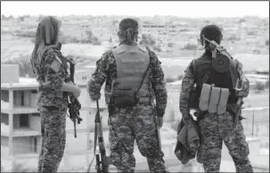  ?? The Associated Press ?? SYRIA: This photo provided Sunday by the Syrian Democratic Forces, shows fighters from the SDF looking toward the northern town of Tabqa, Syria. U.S.-backed opposition fighters led by Syrian Kurdish forces captured more territory from the Islamic State...