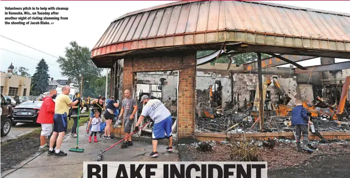  ?? AP ?? Volunteers pitch in to help with cleanup in Kenosha, Wis., on Tuesday after another night of rioting stemming from the shooting of Jacob Blake.