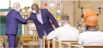  ?? ALEX WONG/GETTY IMAGES ?? Democratic presidenti­al nominee Joe Biden greets Tim Mahone with an elbow bump as he meets Thursday with members of the community at Grace Lutheran Church in Kenosha, Wisconsin.