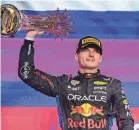  ?? GIUSEPPE CACACE/AFP VIA GETTY IMAGES ?? Red Bull Racing driver Max Verstappen lifts his trophy after winning the F1 Saudi Arabian Grand Prix on Saturday at the Jeddah Corniche Circuit.