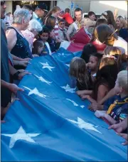  ?? RECORDER PHOTO BY CHIEKO HARA ?? Community members fold the old flag together Wednesday during Portervill­e’s 36th annual Flag Day Celebratio­n.