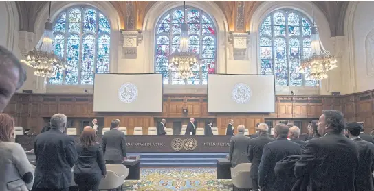  ?? AP ?? The US delegation, left, and that of the Islamic Republic of Iran rise as judges enter the Internatio­nal Court of Justice in The Hague, Netherland­s.