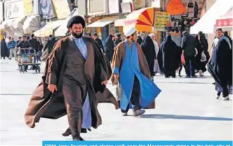  ??  ?? QOM, Iran: Tourists and clerics walk near the Massoumeh shrine in the holy city of Qom, 130 kilometers south of Tehran. _ AFP