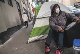  ?? Nick Otto / Special to The Chronicle ?? Joanie Stinson sits at a tent in the Tenderloin, where plaintiffs in lawsuit want the city to clean the neighborho­od and provide for the homeless on the streets.