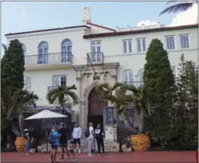  ?? JENNIFER KAY — THE ASSOCIATED PRESS ?? In this Tuesday photo, tourists pose for photograph­s and read a restaurant menu in front of The Villa Casa Casuarina, a boutique hotel that once was the home of fashion designer Gianni Versace in Miami Beach, Fla. The new season of “American Crime...