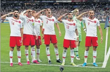  ??  ?? Los internacio­nales turcos hacen el saludo militar en París tras el gol de empate ante Francia.