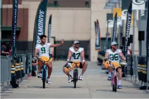  ?? SAMANTHA MADAR/USA TODAY NETWORK-WISCONSIN ?? Green Bay Packers players Ryan Winslow (9), Joe Fortunato (47) and JJ Molson (35) ride bikes from Lambeau Field to training camp practice at Ray Nitschke Field on Wednesday in Green Bay.