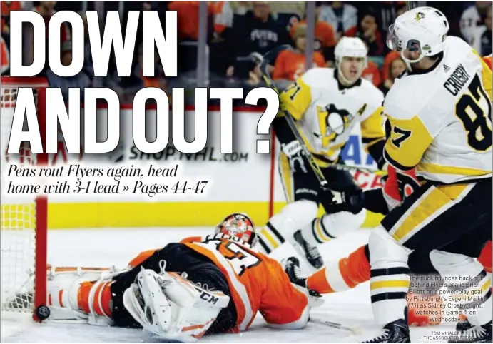  ?? TOM MIHALEK — THE ASSOCIATED PRESS ?? The puck bounces back out behind Flyers goalie Brian Elliott on a power-play goal by Pittsburgh’s Evgeni Malkin (71) as Sidney Crosby, right, watches in Game 4 on Wednesday.