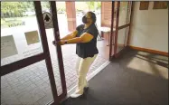  ?? (NWA Democrat-Gazette/Andy Shupe) ?? Annette Clark, a circulatio­n clerk at the Springdale Public Library, shows the broken front automatic doors Sept. 1 that staff must manually push open and closed during the day at the library in Springdale. The library was not included in a planned downtown rejuvenati­on project. Visit nwaonline.com/220918Dail­y/ for today’s photo gallery.