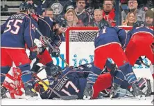  ?? [BROOKE LAVALLEY/DISPATCH] ?? A group of Blue Jackets tries to protect the goal during the first period against the Red Wings.