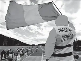  ?? SYLVAIN THOMAS/GETTY-AFP ?? A man with a sign reading “Macron resign” protests against rising oil prices and living costs at a toll booth in Barque.