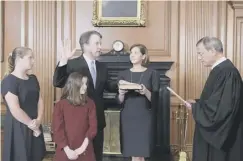  ??  ?? 0 Brett Kavanaugh is sworn in as a supreme court judge as his wife Ashley holds the Bible, watched by daughters Margaret and Liza