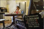  ?? DAVID GOLDMAN - THE ASSOCIATED PRESS ?? Tanya Britton prays before lunch as a sign memorializ­ing babies aborted in the United States hangs on a chair in her kitchen in Tupelo, Miss., May 24. “Whatever I do, let it be for the end of abortion,” 70-year-old Britton prays. “Let it be that one child be saved today. Let it be that Roe v. Wade be overturned.”