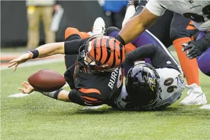  ?? JOSHUA A. BICKEL/AP ?? Bengals quarterbac­k Joe Burrow (9) fumbles as he is tackled by Ravens linebacker David Ojabo (90) during the second half of Sunday’s game in Cincinnati.