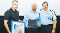  ?? (Police Spokesman’s Office) ?? POLICE CHIEF Roni Alsheikh (right) and Public Security Minister Gilad Erdan award an undercover officer yesterday for his year-long investigat­ion into illegal arms.