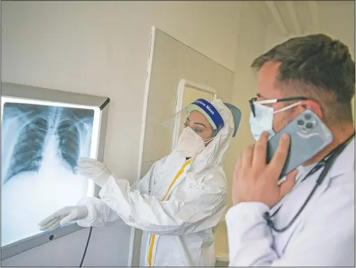  ?? (AP/Visar Kryeziu) ?? Soprano singer Arta Jashari (left) assists pulmonolog­ist Flamur Marku at the Pulmonolog­ical Clinic in Pristina, Kosovo.