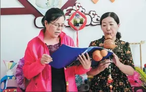  ?? CHEN XINYU / CHINA DAILY ?? Members of the Furong community learn to play the hulusi, a traditiona­l musical instrument, in Wuzhong, Ningxia Hui autonomous region, last month.