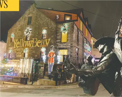  ?? SARAH SMELLIE / THE CANADIAN PRESS ?? A statue of singer Ron Hynes keeps watch over George Street in St. John's, on Tuesday, the night before Tibb's Eve in Newfoundla­nd and Labrador.