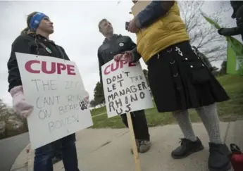  ?? RICK MADONIK/TORONTO STAR ?? Striking workers speak with a picket captain at the main entrance to the zoo, which remains closed to the public.