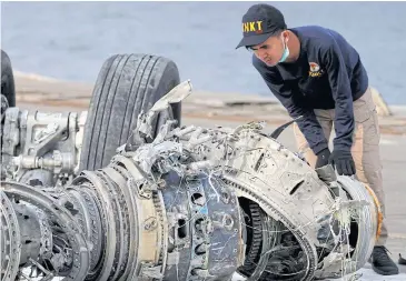  ??  ?? LOOKING FOR CLUES: An Indonesian National Transporta­tion Safety Commission official examines a turbine engine from the Lion Air flight JT610 in Jakarta, Indonesia.