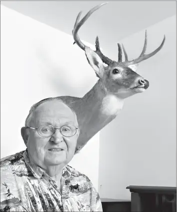  ?? Associated Press ?? Jim Moore poses with the whitetail deer he shot in Pottawatom­ie County on display at his home in Oklahoma City.