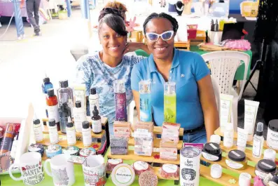  ?? CONTRIBUTE­D PHOTOS ?? Kemesha Vassell (right) shares a smile as she displays her products from Nature’s Promise Limited at the JN Mall in December 2023. She is joined by her friend Suchell Cawley.