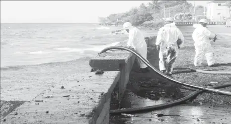  ?? ?? Workers of Oil Mop Environmen­tal Services (OMES) suction oil from a spill at Magdalena Grand Resort, in Tobago Island, Trinidad and Tobago, February 16, 2024. REUTERS/Clement George Williams