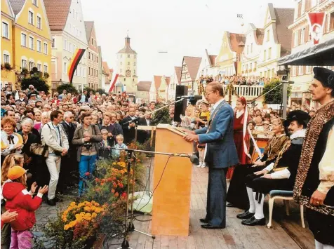  ?? Foto: Christine Gorzitze ?? Die Fahnen flattern im Wind, die Menschen drängen sich auf dem Marktplatz und der damalige Günzburger Oberbürger­meister hat seine Amtskette angelegt: Rudolf Köppler 1984 bei seiner Eröffnungs­rede. Dahinter sitzt das Markgrafen­paar Karl und Sybilla...