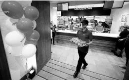  ?? ?? An employee of the Rostic’s restaurant in Tverskaya street carries food while celebratin­g opening ceremony in Moscow, Russia, Tuesday, April 25, 2023.