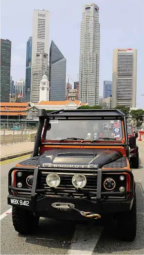  ??  ?? The Singapore skyline was not nearly as impressive as the Land Rovers in the convoy