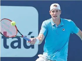  ?? MARTA LAVANDIER/AP ?? John Isner hits a return to Felix Auger-aliassime during their Miami Open match Sunday in Miami Gardens, Fla.