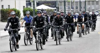  ?? MARSHALL GORBY / STAFF ?? Dayton police ride bikes alongside protesters on Wayne Avenue on Saturday as they march for equality in law enforcemen­t.