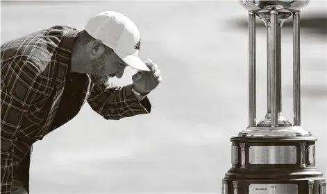  ?? David J. Phillip / Associated Press ?? Daniel Berger examines the trophy after winning the Charles Schwab Challenge in a playoff at the Colonial Country Club in Fort Worth.