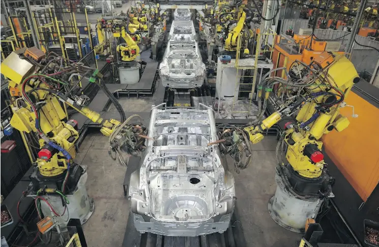  ?? OLI SCARFF/AFP/GETTY IMAGES/FILE ?? Robots weld vehicle panels in the body shop in Nissan’s Sunderland plant in northeast England. The plant is the European home of Nissan and the largest car-assembly facility in the United Kingdom, producing around half a million vehicles per year while...