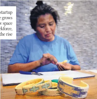  ?? JIM THOMPSON/ JOURNAL ?? Drucilla Chackee of To’hajiilee stitches beads onto a leather bracelet at Etkie’s new space on Fourth NW. The company sells jewelry and Native American arts.