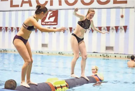  ?? UW-LA CROSSE ?? Gabriella Zaemisch (right), a freshman from Stoughton, competes against another student at UW-La Crosse, which offered logrolling as an activity during finals.