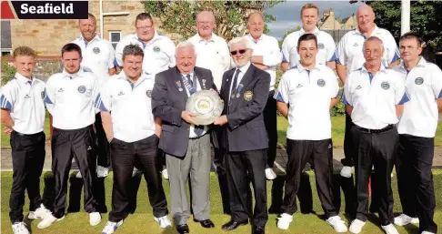  ??  ?? Seafield stars President Bob Cowan receives the trophy from Ayr Trophies president Hugh Brown