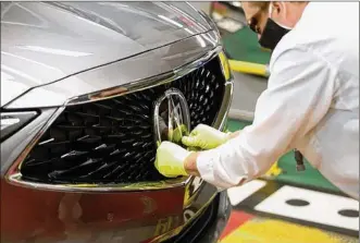  ?? ACURA IMAGE ?? The Acura logo is carefully installed on a completed 2022 Acura MDX at the East Liberty Auto Plant. Honda says the 4th-generation MDX has been “completely redesigned from the ground up.”