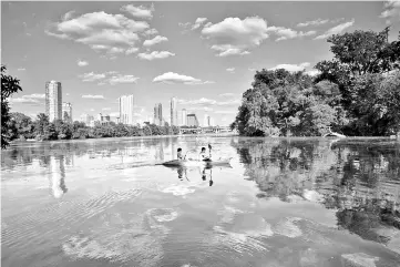  ??  ?? Kayakers take in the skyline from Lady Bird Lake, which is encircled by a hiking-and-biking trail that stretches more than 10 miles.