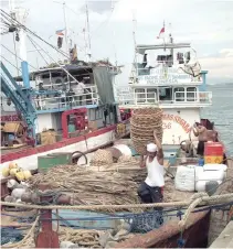  ??  ?? A CREW of a fishing vessel cleans up before heading for another catch.