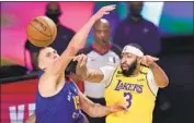  ?? Mark J. Terrill Associated Press ?? ANTHONY DAVIS passes out of the defense of Denver’s Nikola Jokic in the Lakers’ Game 1 win.