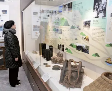  ??  ?? A visitor looks at a map of the Mackerel roads displayed at the Saba Kaido Museum in Obama.