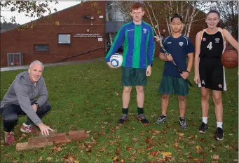  ??  ?? PE teacher Mr Megitegan with students Nathan O’Connor, Trí O’Gorman and Rhiannon Wynne O’Sullivan on the spot where the new East Glendaloug­h School sports hall will be built.