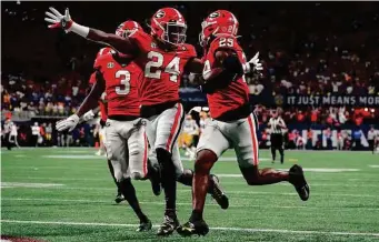  ?? John Bazemore/Associated Press ?? Georgia defensive back Malaki Starks, center, celebrates as teammate Christophe­r Smith returns a blocked LSU field-goal attempt for a touchdown in the first quarter.