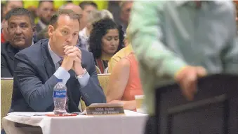  ?? GREG SORBER/JOURNAL ?? University of New Mexico Athletic Director Eddie Nuñez, left, listens to speakers discussing proposed Athletics’ cuts at the UNM regents meeting in the Student Union on July 19.