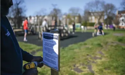  ??  ?? A council worker puts up a sign notifying the closure of an outdoor gym on Clapham Common in London. Photograph: Peter Summers/ Getty Images