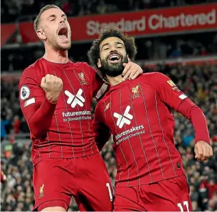  ?? GETTY IMAGES ?? Liverpool’s Mohamed Salah, right, celebrates with Jordan Henderson after Salah’s winning goal against Tottenham Hotspur yesterday.