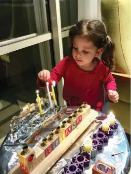  ?? (Pnina Peretz) ?? THREE-YEAR-OLD Eliana Peretz of Modi’in lights her hanukkia.